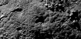 A possible ice volcano on Pluto (visible at center) is seen in this NASA image, captured by the New Horizons spacecraft, released on Nov. 9, 2015. The feature, called Wright Mons, is a strange feature 100 miles wide and 13,000 feet high with a summit depression at its center. New Horizons scientists suspect Wright Mons and another mountain may be signs of cryovolcanic eruptions on Pluto. Credit: NASA/Johns Hopkins University Applied Physics Laboratory/Southwest Research Institute