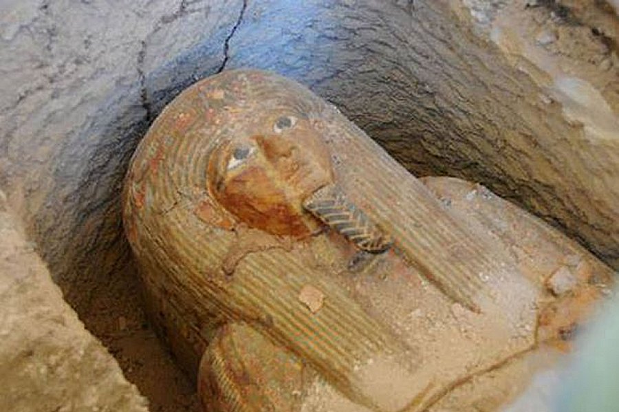 “The sarcophagus is made of wood and covered with a layer of plaster. It represents the deceased wearing a wig and crown with flowers and colorful ribbons along with ceremonial beard and a necklace adorning his chest.”