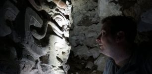 Garrison comes face to face with a mask inside one of the site’s pyramids. (USC Photo/Robert Perkins)