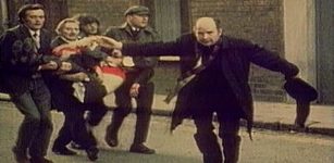 Father Edward Daly waving a blood-stained white handkerchief while trying to escort the mortally wounded Jackie Duddy to safety. Credits: Wikipedia