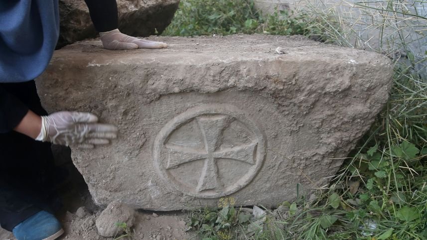 Palestinian archaeologist Hyam al-Betar looks at a foundation stone bearing a Greek Christian symbol excavated during the construction of a commercial building in Gaza City, on April 4, 2016 which is believed to be the site of an ancient church (AFP Photo/Mohammed Abed)