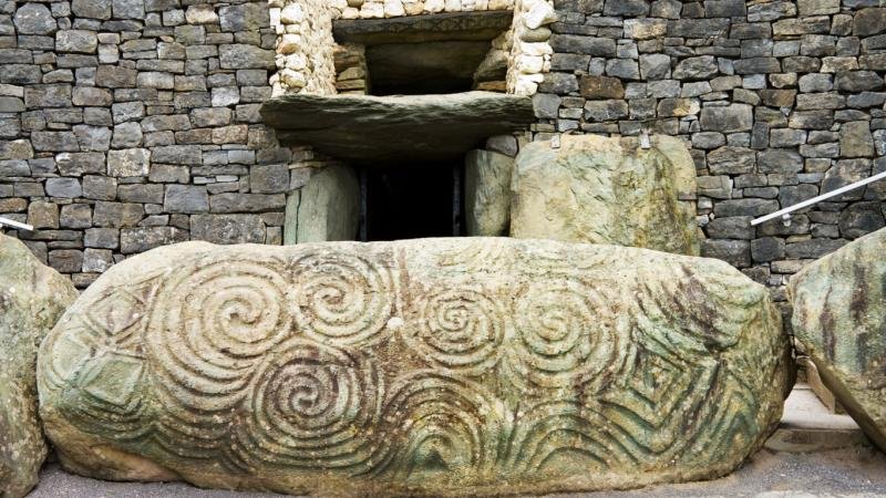 (((( A decorated stone at the entrance to the tomb at Newgrange. Image via irishtimes.com