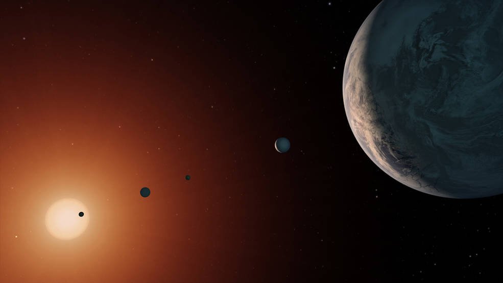 This illustration shows what the TRAPPIST-1 system might look like from a vantage point near planet TRAPPIST-1f (at right). Credits: NASA/JPL-Caltech