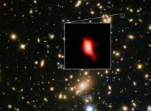 This image shows the galaxy cluster MACS J1149.5+2223 taken with the NASA/ESA Hubble Space Telescope; the inset image is the very distant galaxy MACS1149-JD1, seen as it was 13.3 billion years ago and observed with ALMA. Here, the oxygen distribution detected with ALMA is depicted in red. Credit: ALMA (ESO/NAOJ/NRAO), NASA/ESA Hubble Space Telescope, W. Zheng (JHU), M. Postman (STScI), the CLASH Team, Hashimoto et al.