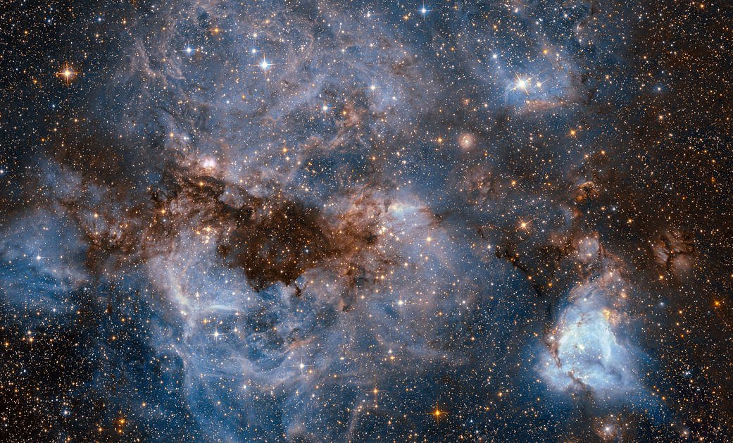 This shot from the NASA/ESA Hubble Space Telescope shows a maelstrom of glowing gas and dark dust within one of the Milky Way’s satellite galaxies, the Large Magellanic Cloud (LMC). Image credit: ESA/Hubble & NASA