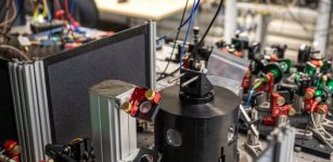 Alice, the receiver of the teleported quantum information. Inside the black aluminium cylinder, the diamond sample is cooled to -270°C, to reduce the noise from the environment and enable the quantum control. Credit: Marieke de Lorijn for QuTech