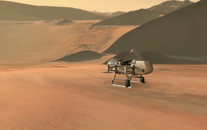 This illustration shows NASA’s Dragonfly rotorcraft-lander approaching a site on Saturn’s exotic moon, Titan. Taking advantage of Titan’s dense atmosphere and low gravity, Dragonfly will explore dozens of locations across the icy world, sampling and measuring the compositions of Titan's organic surface materials to characterize the habitability of Titan’s environment and investigate the progression of prebiotic chemistry. Credits: NASA/JHU-APL