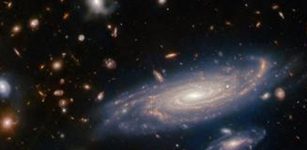 The big galaxy in the foreground is named LEDA 2046648, and is seen just over a billion years back in time, while most of the others lie even farther away, and hence are seen even further back in time. ESA/Webb, NASA & CSA, A. Martel.