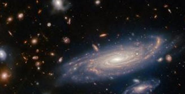 The big galaxy in the foreground is named LEDA 2046648, and is seen just over a billion years back in time, while most of the others lie even farther away, and hence are seen even further back in time. ESA/Webb, NASA & CSA, A. Martel.
